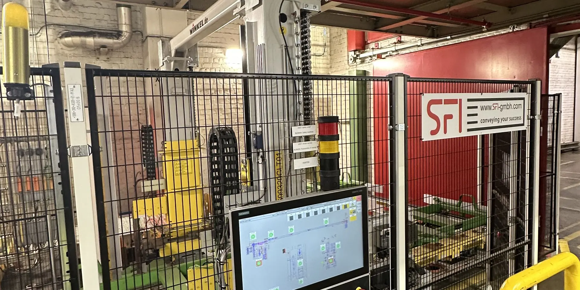 Anlagenbereich mit HMI-Bedienpanel und Schutzumzäunung